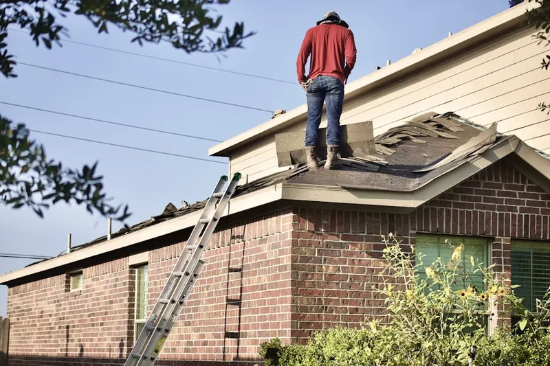 Professional roofer working on a residential roof in Klahr